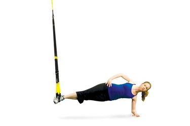 Woman performing TRX side plank.