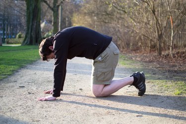 Man performing cat-cow stretch before a bike ride