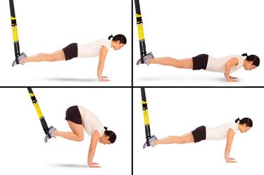 Woman performing atomic push-up with crunch TRX exercise