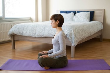 Woman demonstrating how to do Lotus pose yoga for sleep