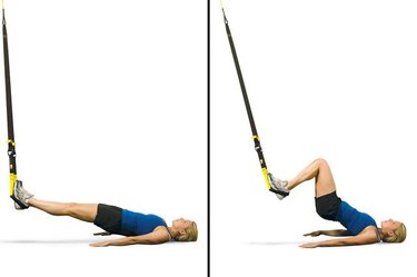 Woman performing TRX hamstring curl.