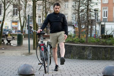 Man performing leg swing before a bike ride