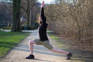 Man performing dynamic runner's lunge before a bike ride