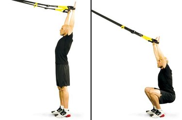 Man performing overhead squat TRX exercise