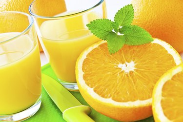 Glass of juice next to an orange