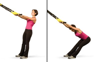 Woman performing lower back stretch TRX exercise