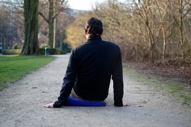 Man foam rolling muscles on ground before a bike ride