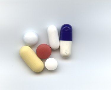 Collection of different colored pills on a white background.