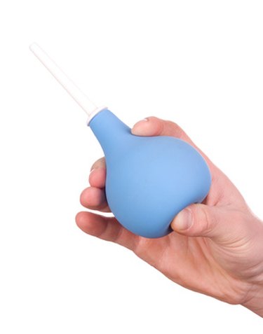 A hand holding a suction device against a white background.