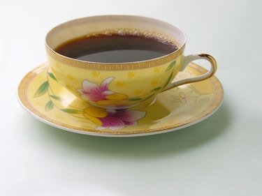 yellow flower mug of coffee on matching saucer