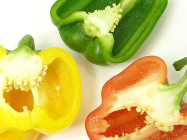 top-down photo of green, yellow, and red bell pepper halves
