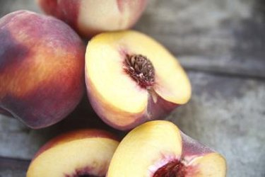 Halved peaches on grey background to illustrate peaches and diabetes