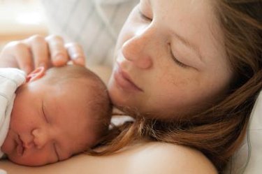 a close up photo of a parent holding an infant on their chest