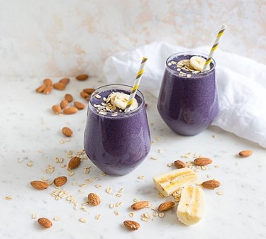 Blueberry Almond Milk Smoothie in two glasses on marble countertop.