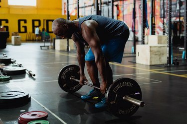 Man doing barbell deadlift in the gym.