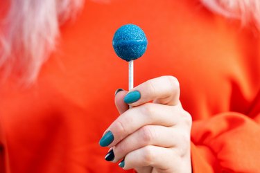 woman holding a bright blue lollipop