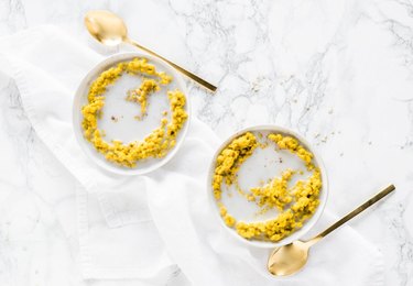 Turmeric Golden Milk Oatmeal in two bowls on marble countertop.