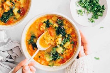 A serving of Anti-Inflammatory Veggie Soup with Turmeric. in a white bowl