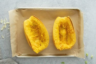 Cooked spaghetti squash on baking sheet