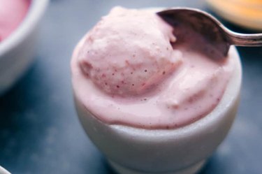 a small white bowl of slightly melted homemade raspberry frozen yogurt