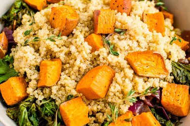 Cubes of sweet potatoes on a bed of quinoa and kale.