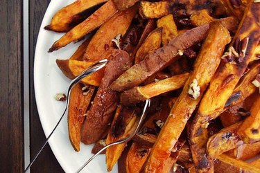 Sweet potato steak frites with pecans on a white plate.