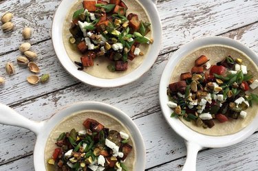 Sweet potato tacos with feta on white dishes on a wooden table.