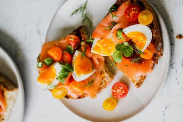 Smoked salmon, tomatoes and egg top some thick whole grain toast.