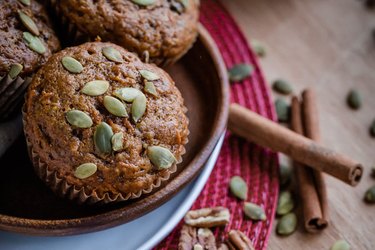 Pumpkin Carrot Muffins in a brown bowl on wooden table