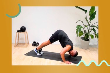 Man doing a pike push-up — one of the hardest arm exercises — on a yoga mat in a fitness studio