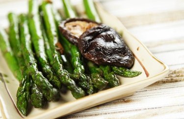 asparagus and shiitake mushrooms on a serving try on wooden table