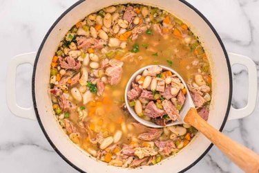 An overhead photo of a bowl of Ham And Bean Soup with a spoon