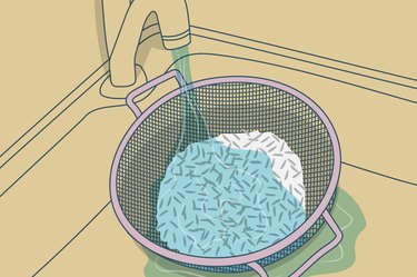 插图滤器的大米在水槽水龙头下冲洗。