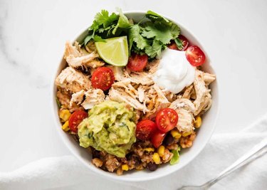 Instant Pot Chicken Taco Bowls in white bowl with sour cream and guac