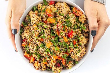 Lebanese-Inspired Quinoa Salad in white bowl in hands