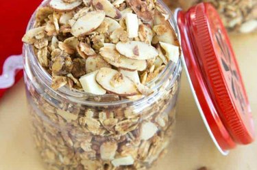 Slow cooker eggnog granola in a mason jar with a red lid on a wooden table