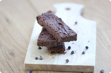 Fudge Brownie Chocolate Protein Bars on a wooden cutting board on wooden table.