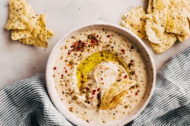 Instant Pot Hummus in speckled bowl next to cracker chips.