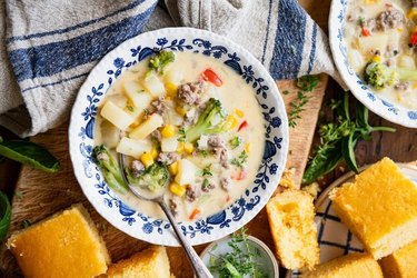 Cheesy Sausage Potato Soup in blue-and-white bowls with matching napkin