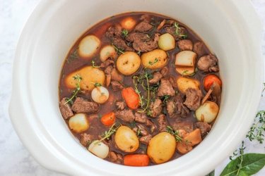 Slow Cooker Beef Bourguignon in a white pot on marble countertop.