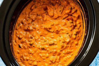 Close up of slow cooker potato and chickpea tikka masala in a black slow cooker