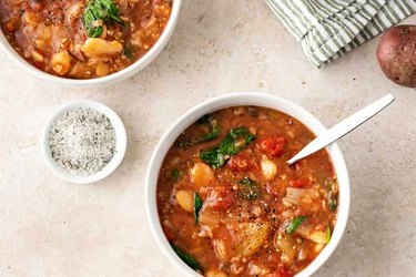 Wide shot of slow cooker lima bean tomato stew in two white bowls