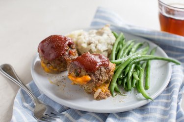 High Protein Muffin Tin Dinner Cheesy Meatloaf Minis on a white plate with green beans and mashed potatoes and a fork