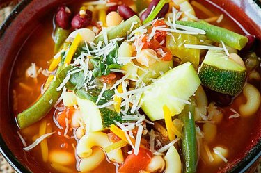 Crockpot Minestrone Soup with green veggies and red broth in a slow cooker.