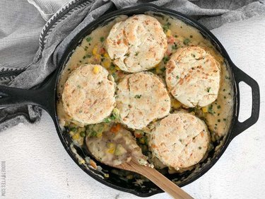 Vegetable Pot Pie Skillet With Cheddar Biscuit Topping in a skillet on white table.