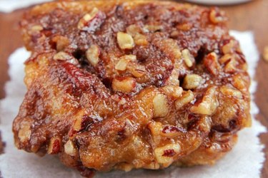 Slow cooker sticky pecan buns on parchment paper.