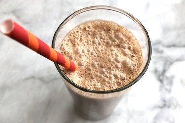 Vegan chocolate nut shake with sea salt with a straw in a glass