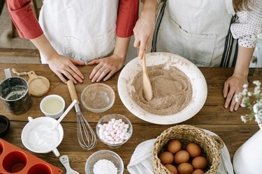 an overhead photo of two people baking in a kitchen using canola oil, a type of seed oil