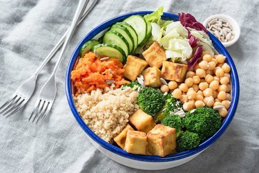 Glorius tofu buddha bowl with creamy soy dressing on a gray tablecloth