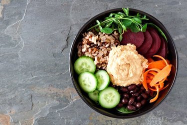 Beet and carrot bowl with savory dressing on a stone background